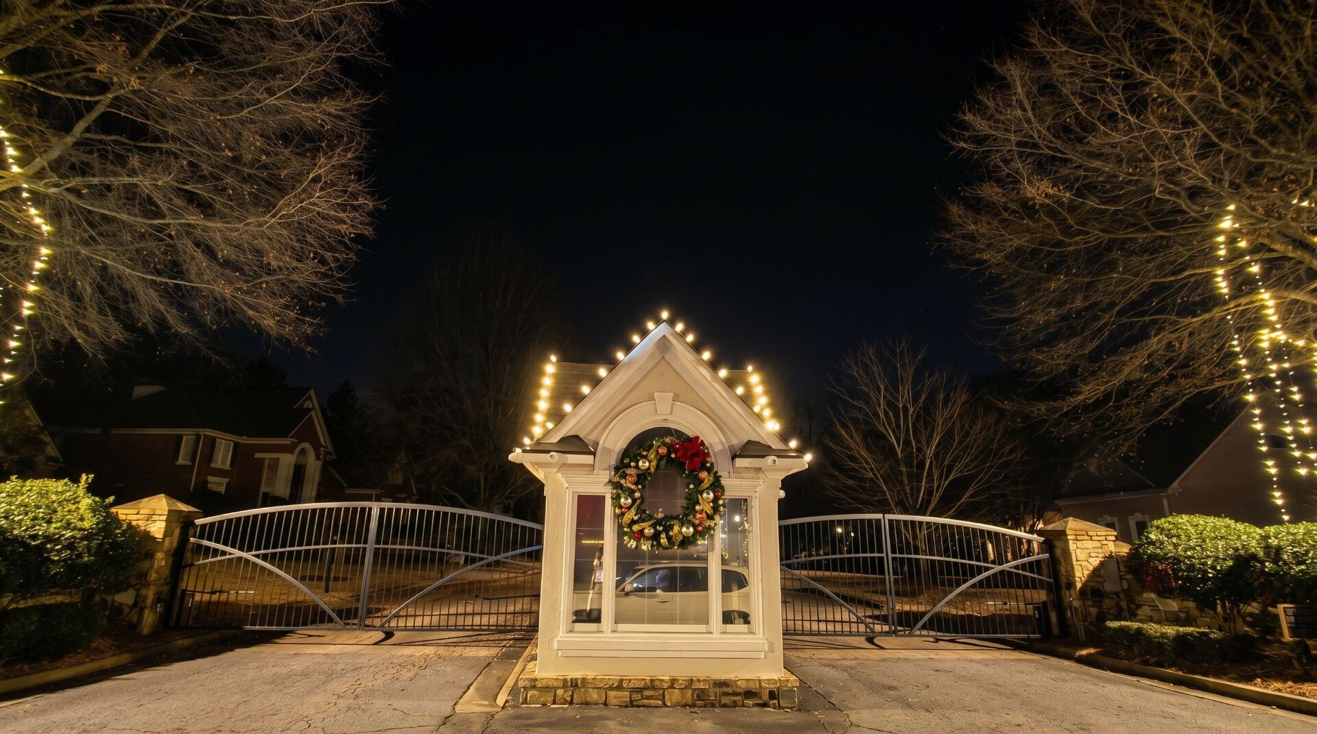 HOA guardhouse with holiday wreath and roofline Christmas lights in Buckhead community