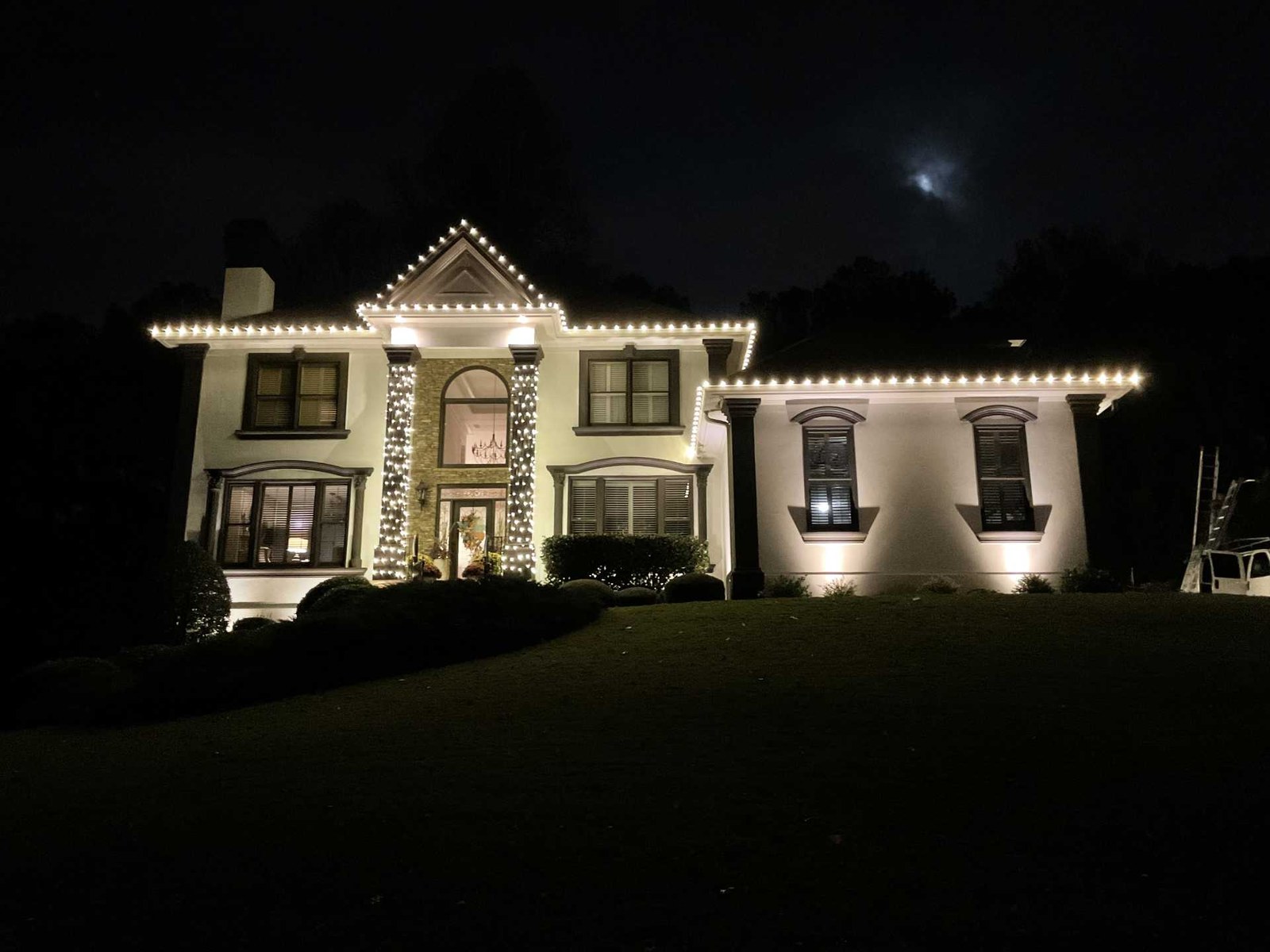 Bright white Christmas lights on stucco Atlanta home with wrapped columns