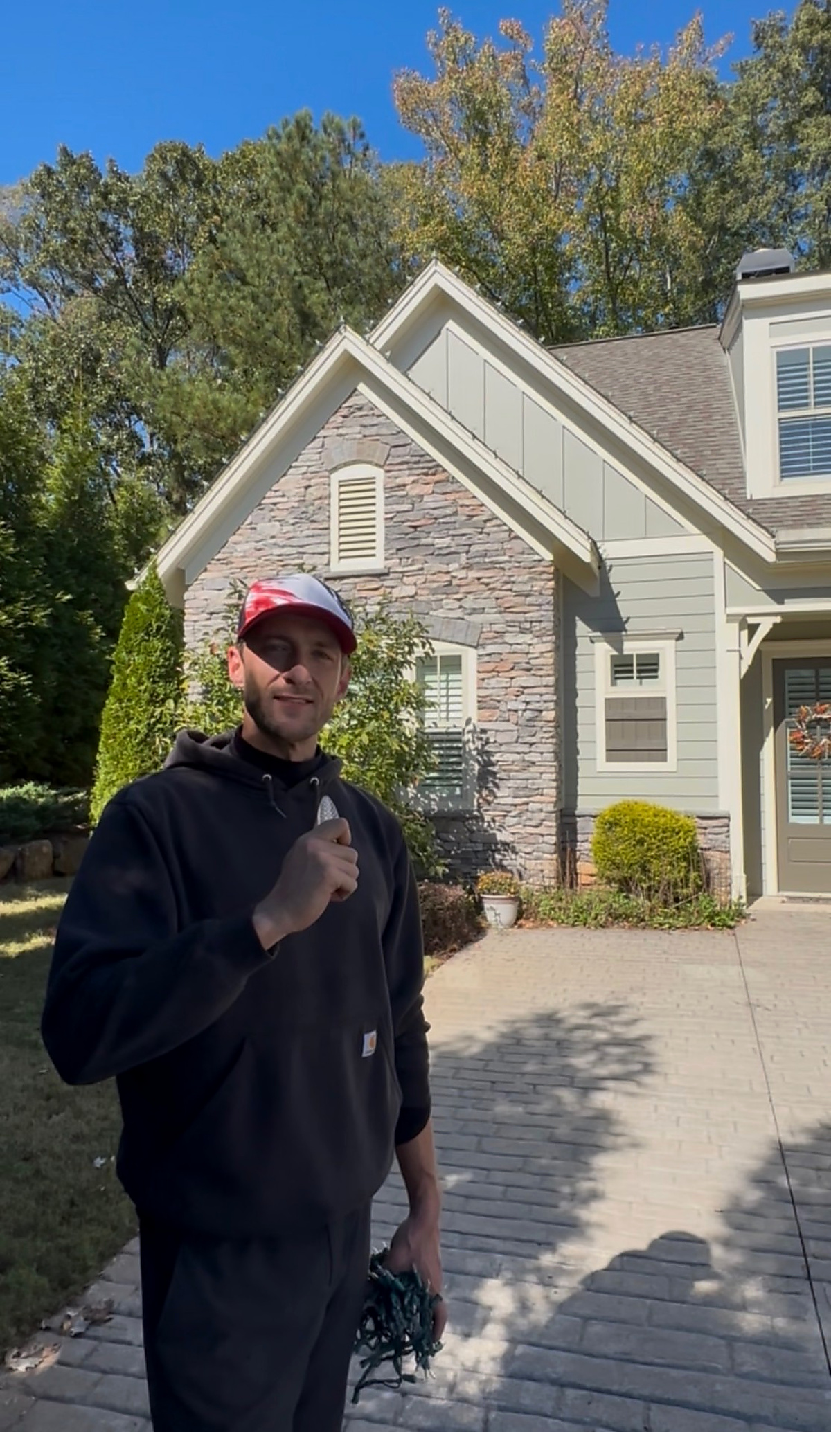 Dreamland owner in front of a stone-front Atlanta home ready for Christmas light installation