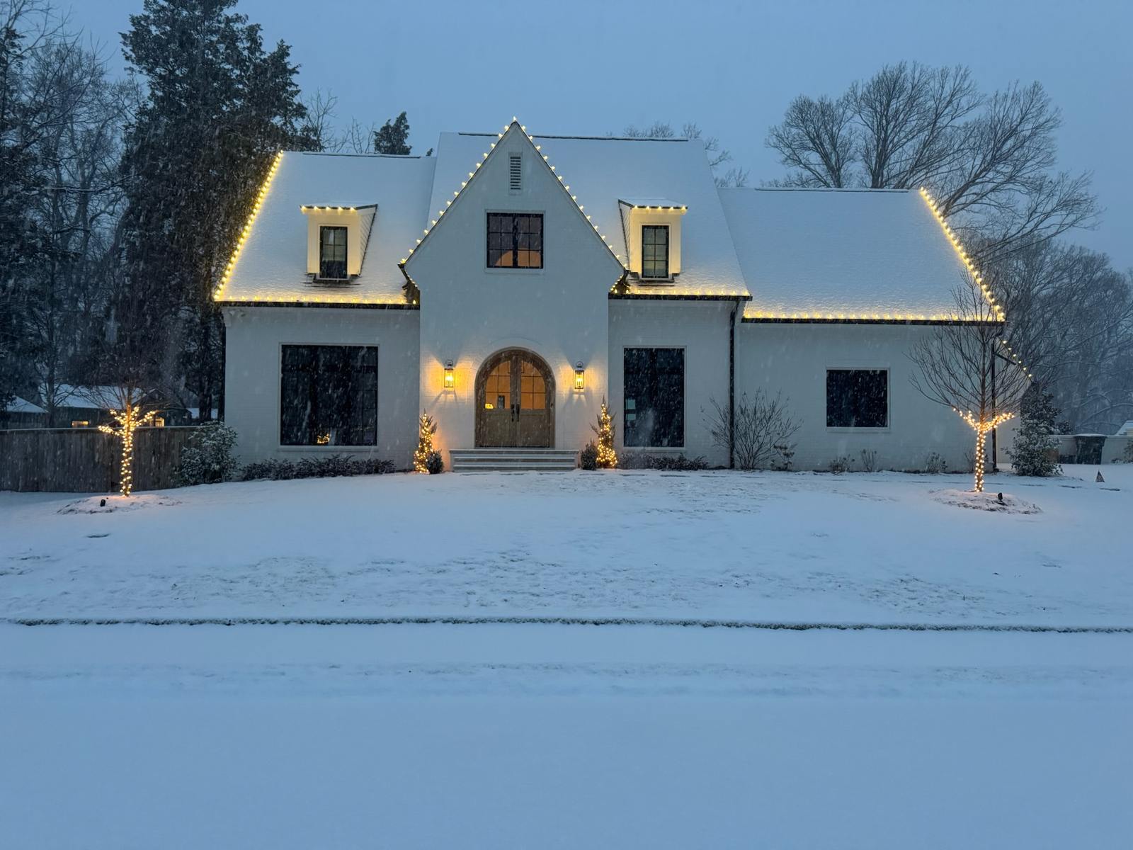 Snow covered Christmas lights on Atlanta metro home with lit trees