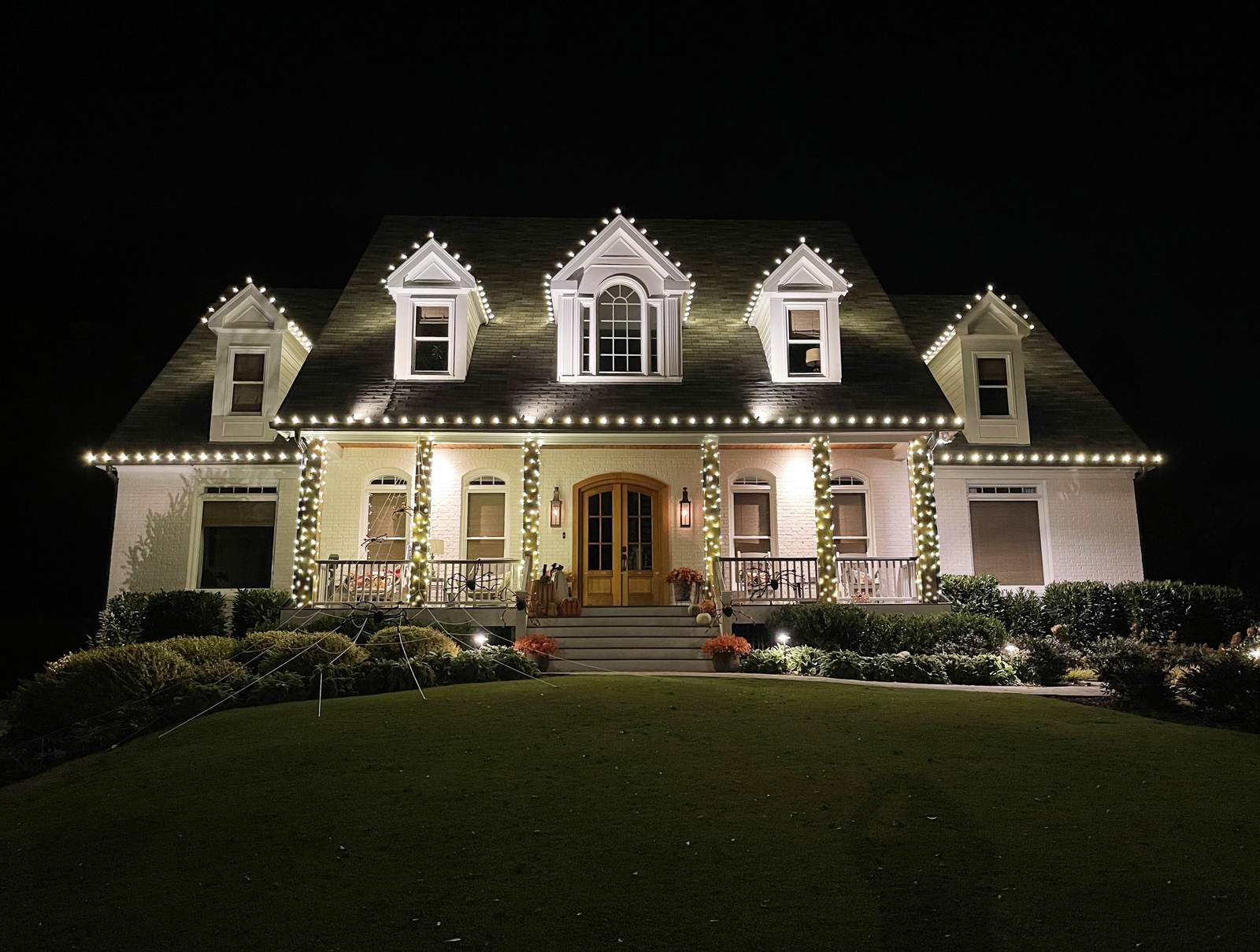 Atlanta Christmas lights on white porch home with dormer C9 lighting