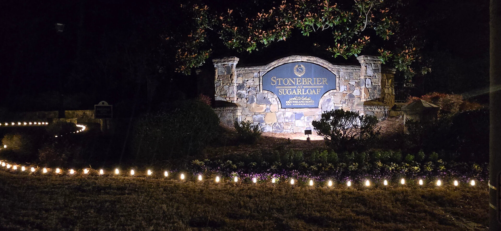 Stonebrier at Sugarloaf HOA monument sign with holiday pathway lights