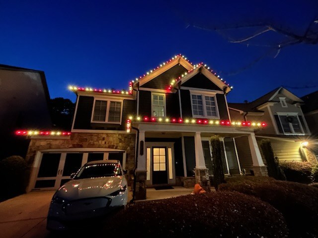 Red and white roofline Christmas lights on two story Atlanta GA home at dusk