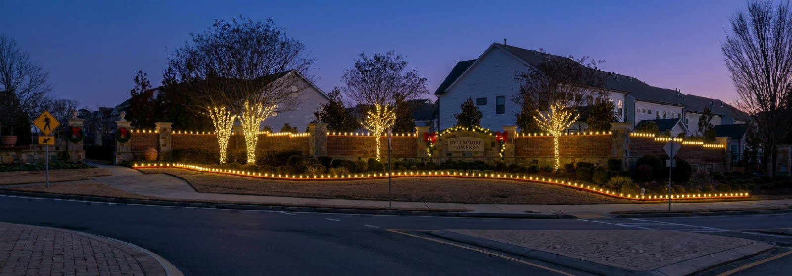 HOA community entrance with warm white Christmas lights in Atlanta